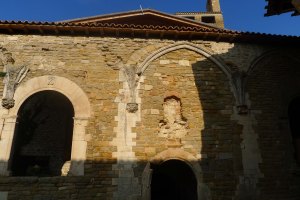 Façana de l'església amb restes del claustre. A l'esvoranc de la pared hi havia una imatge de Sant Pere.
